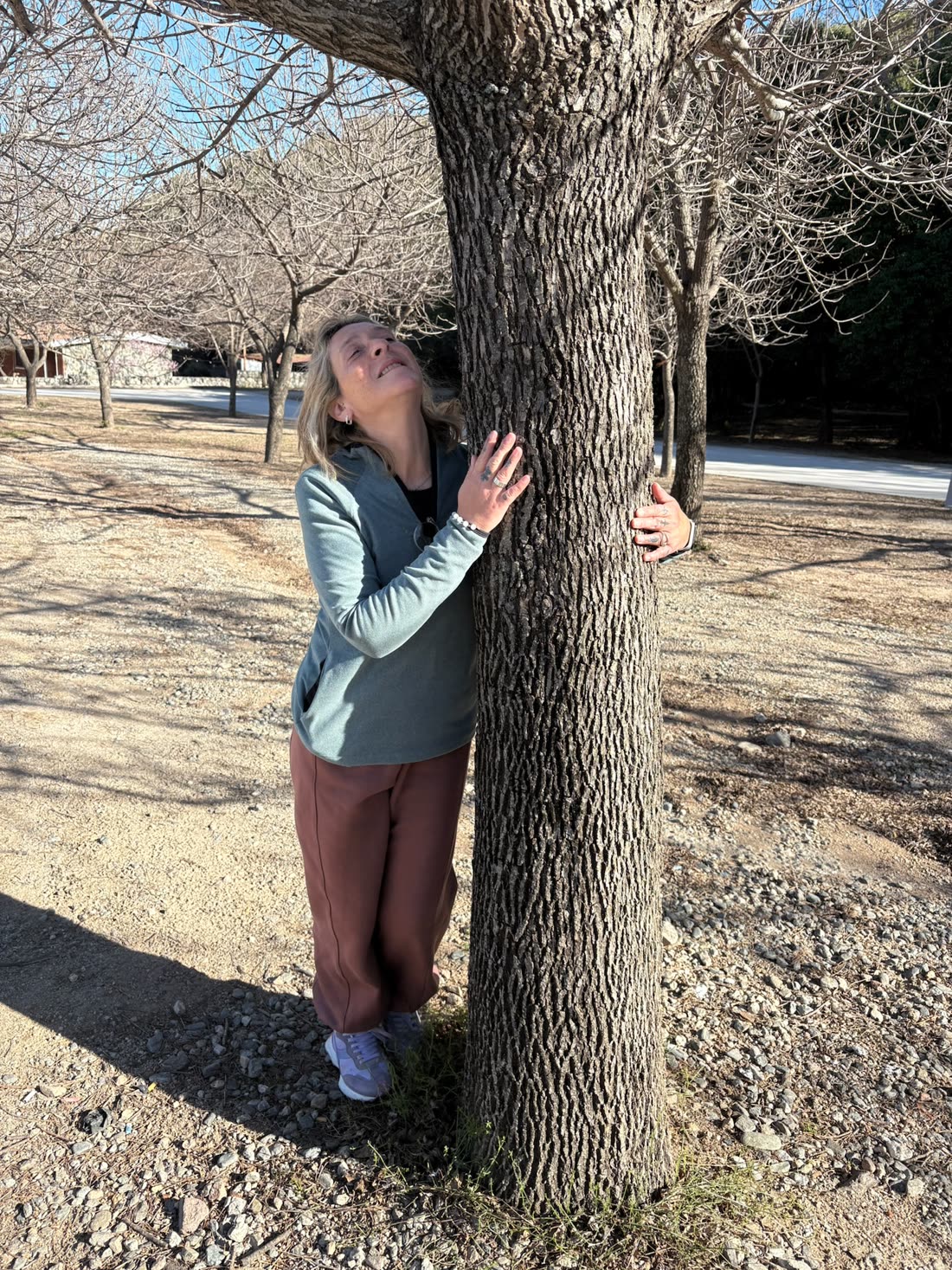 Eleonora abrazada a un árbol